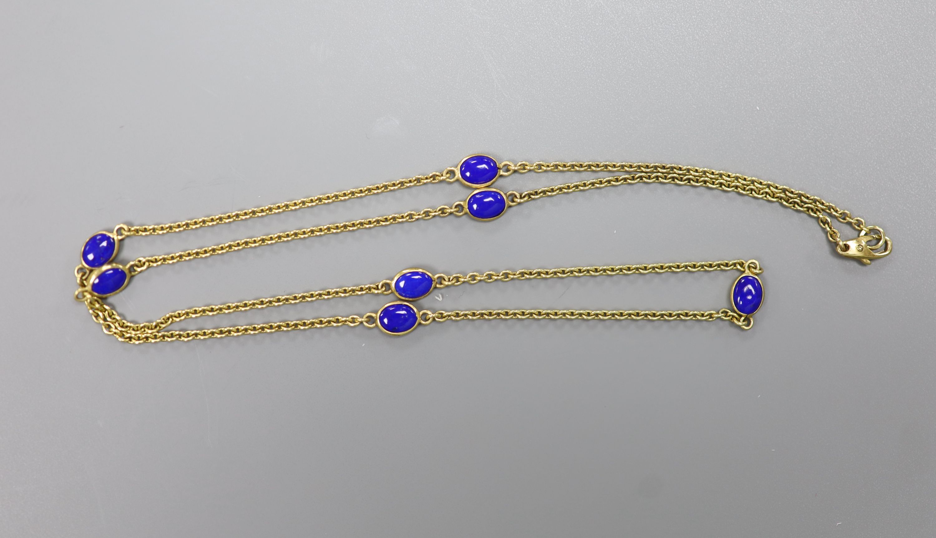 A modern 9ct gold and seven stone cabochon lapis lazuli set 'spectacle' necklace, 55cm